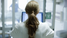 Healthcare provider standing with their back facing the camera in a clinic