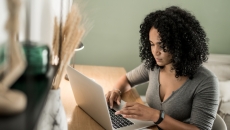 Person sitting at a desk and looking at a computer