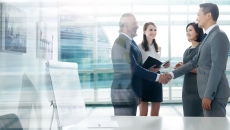 Two people shaking hands while two others are watching