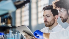 Two researchers looking at a tablet computer