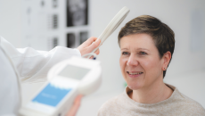 A doctor measuring a patient's intracranial pressure using an implantable sensor