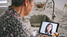 Person interacting with healthcare professional via tablet