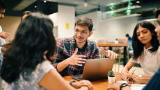 Group of individuals sitting around a table talking