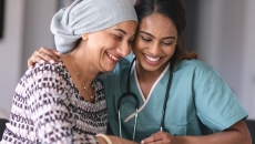 Two people sitting with one embracing the other