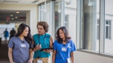 three people walking together in a hospital