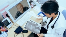 Doctor consulting with patient via computer