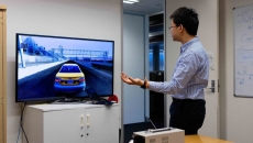 A student demonstrating the use of a sensor bracelet for hand-impaired persons