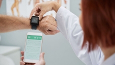 A doctor helping a patient set up a wearable watch