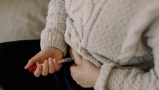 A close up of a person injecting fertility medication into their abdomen