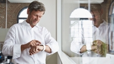 A man in an office wearing a smartwatch