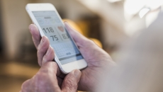 A smartphone displaying blood pressure data and a chart with trends