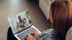 A woman talking to a doctor through a video chat on her laptop.