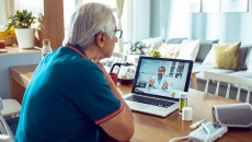An older man talking to a provider via telehealth