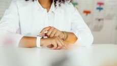 A close-up of a person sitting while wearing a smartwatch