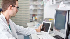 Healthcare professional sitting at a desk looking at a computer