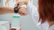 A doctor synchronising a patient's smartwatch with their mobile app