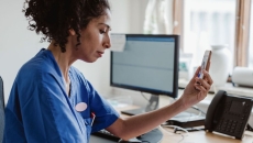 A doctor talking to a patient through a video call on her smartphone