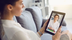 A person talking to a provider via a video chat on a tablet.