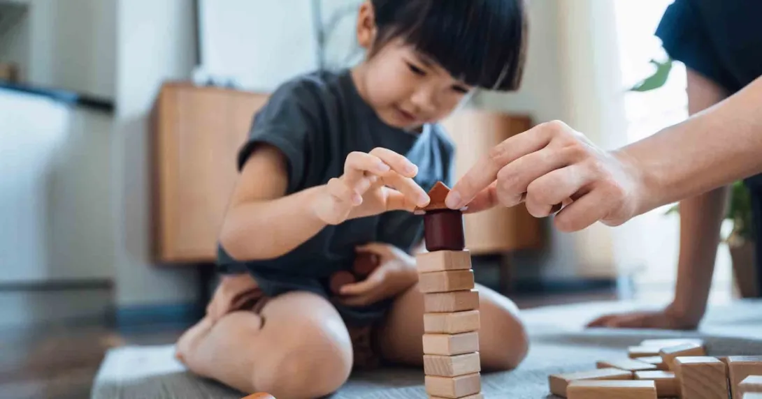 Person playing with blocks while sitting on the floor