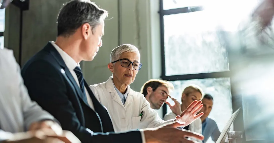 Healthcare providers and business people sitting a room together