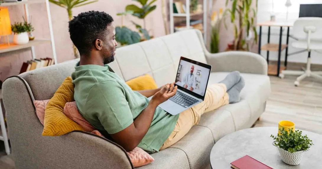 Person sitting on a couch while having a telehealth appointment