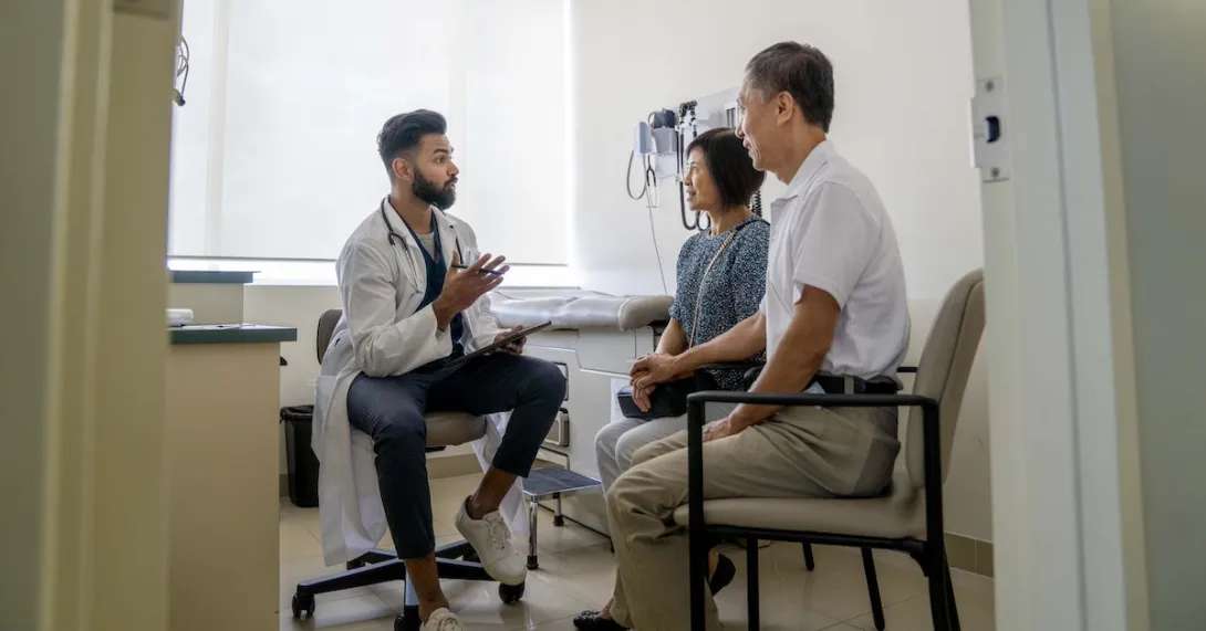 Doctor sitting in an exam room with two patients