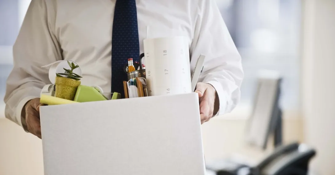 A worker holding a box of his belongings