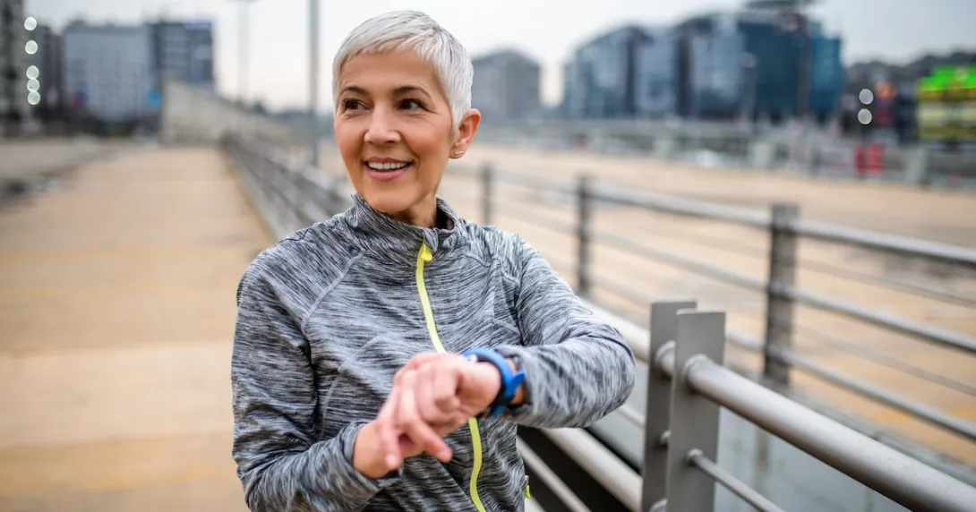 Person looking at smartwatch while standing outdoors