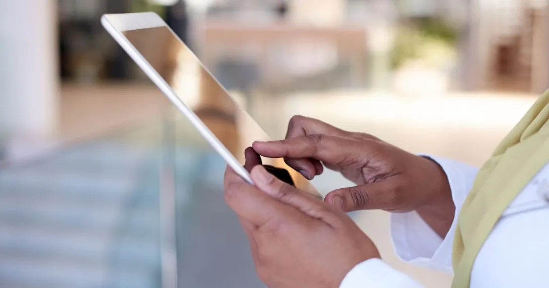 A close up photo of a doctor using a tablet.