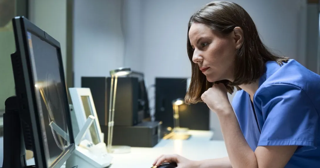 A doctor using a desktop computer.