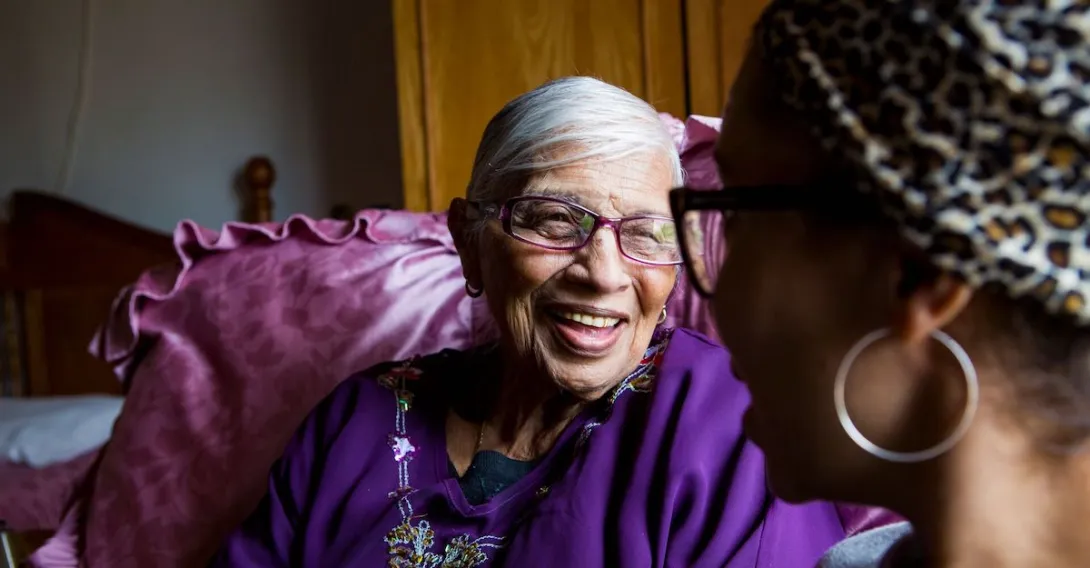 An older woman sitting with a younger woman at home.