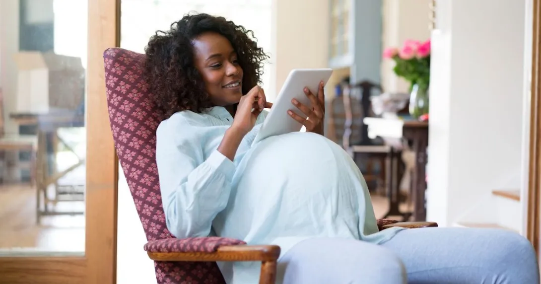 A pregnant woman using a tablet