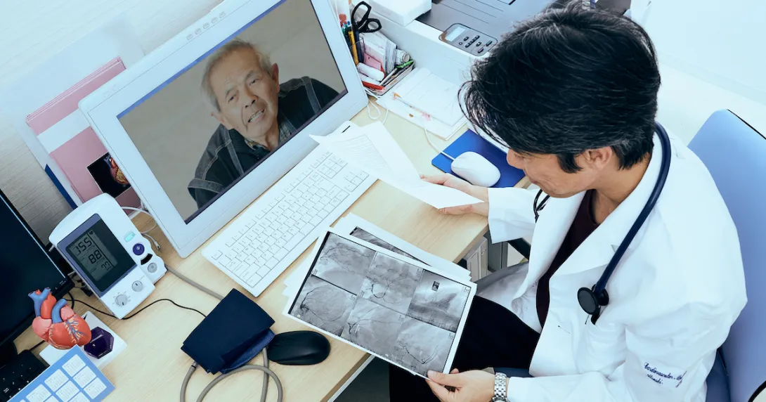 A provider holding imaging results talking to a patient via telehealth
