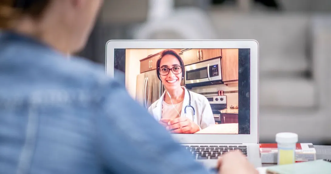 A person talking a doctor via a video chat on their laptop.