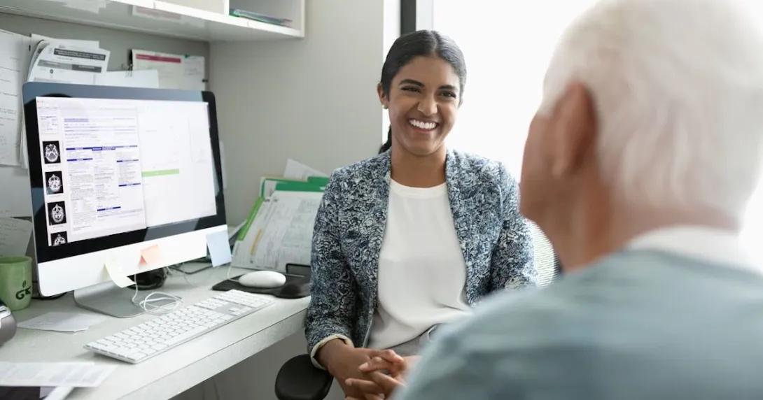 A mental healthcare provider talking to an older patient in the foreground