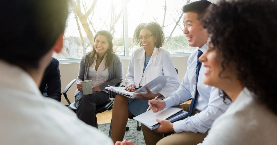 Five business people sitting on chairs in a circle