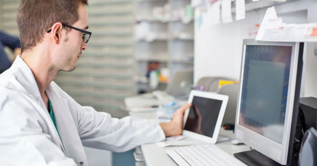 Healthcare professional sitting at a desk looking at a computer